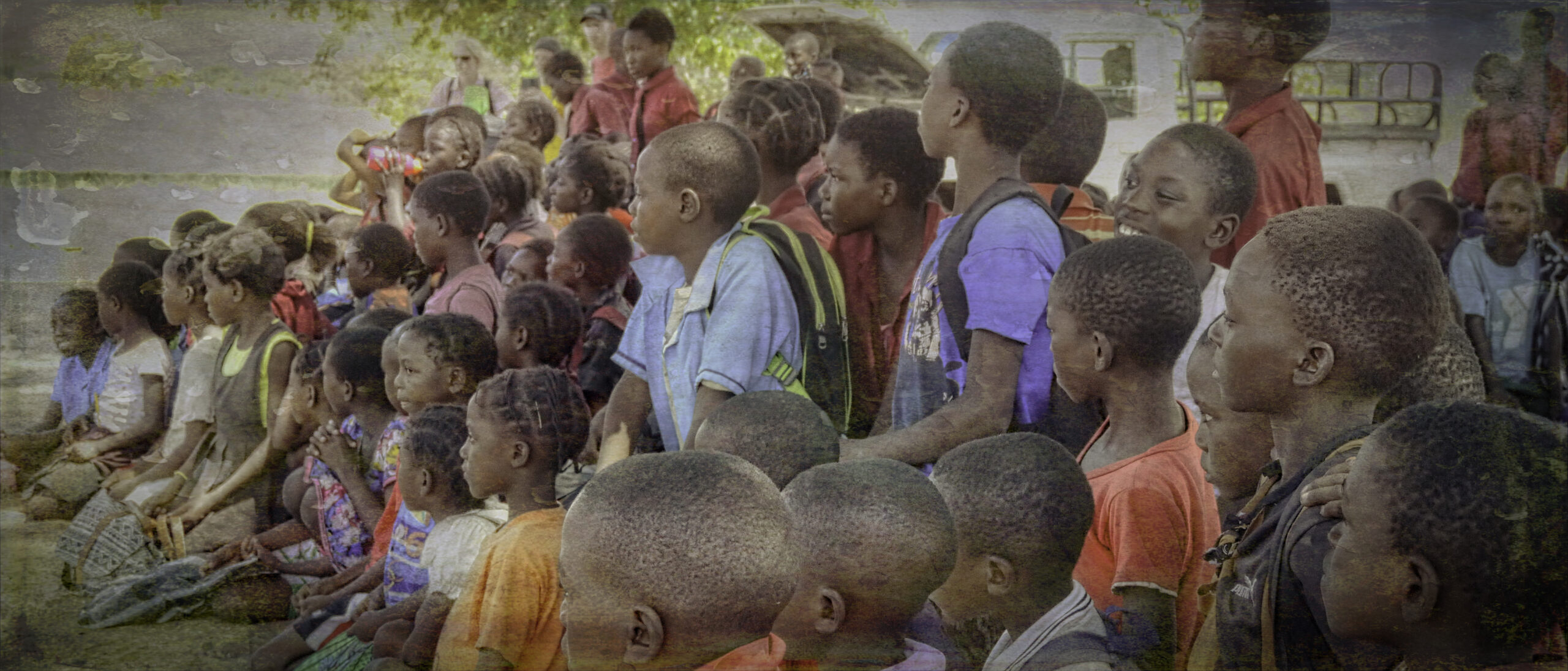 Children in Zambia listening to someone speak.