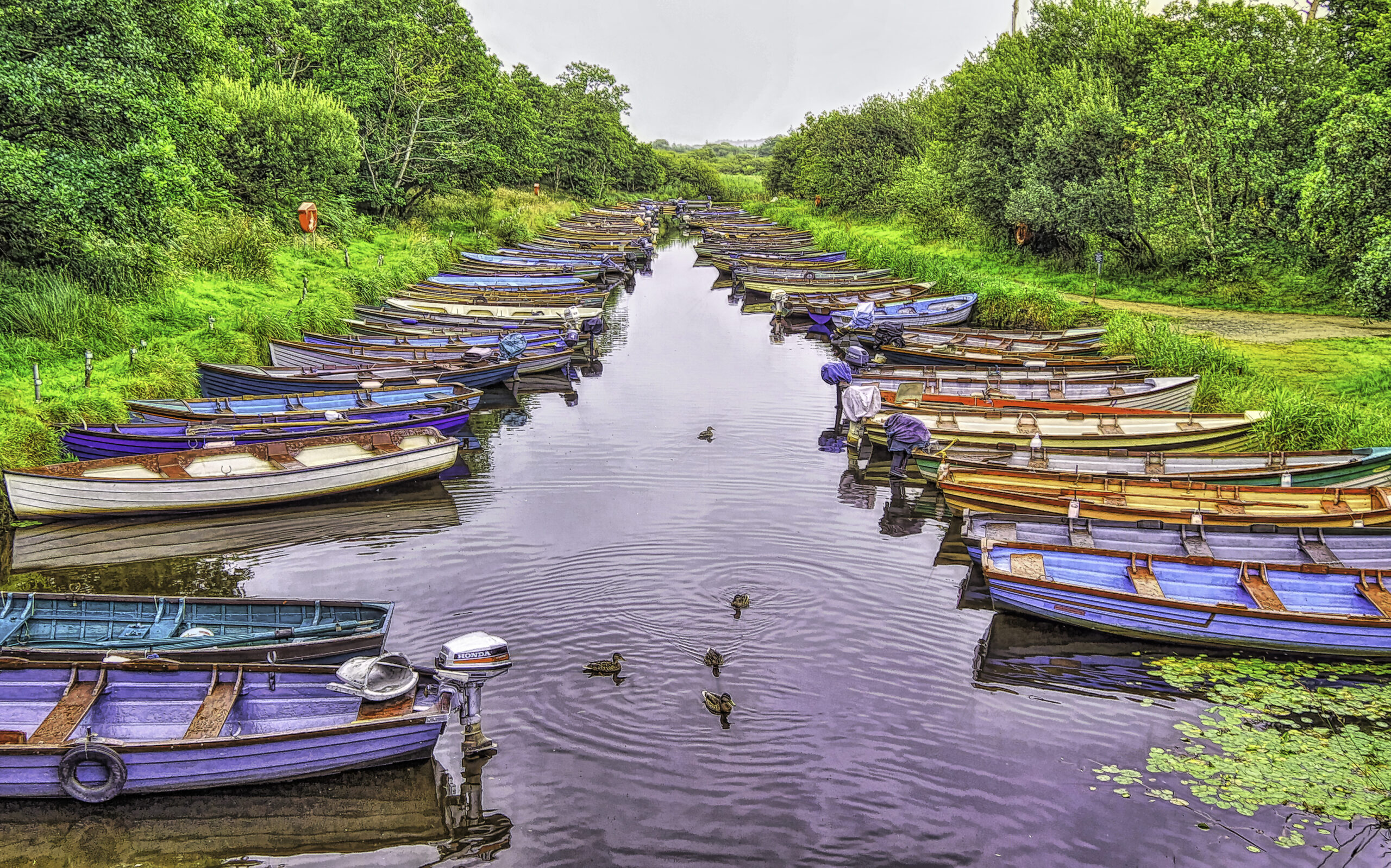 Boats lined up on both sides of a stream in Killarney, Ireland