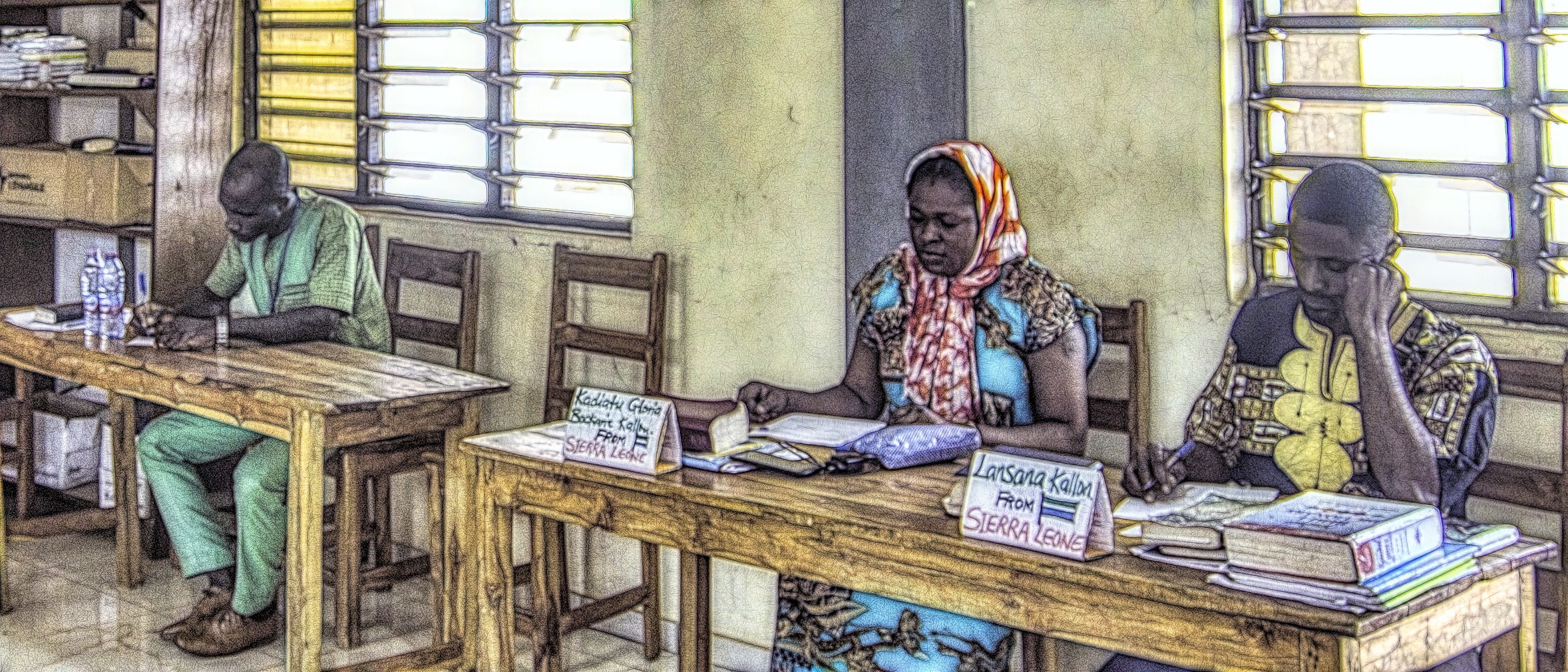 Three students in a classroom in Lome, Togo taking a test